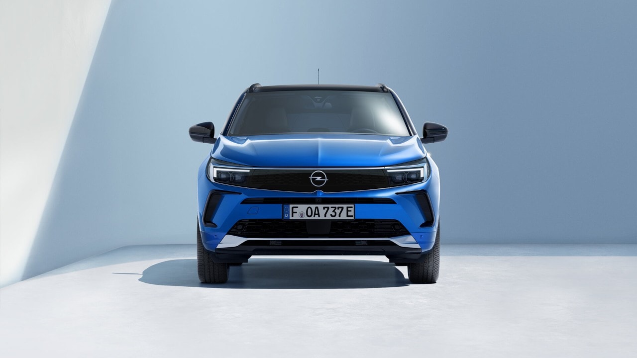 Vooraanzicht van een blauwe Opel Grandland Plug-in Huybrid met een zwart dak